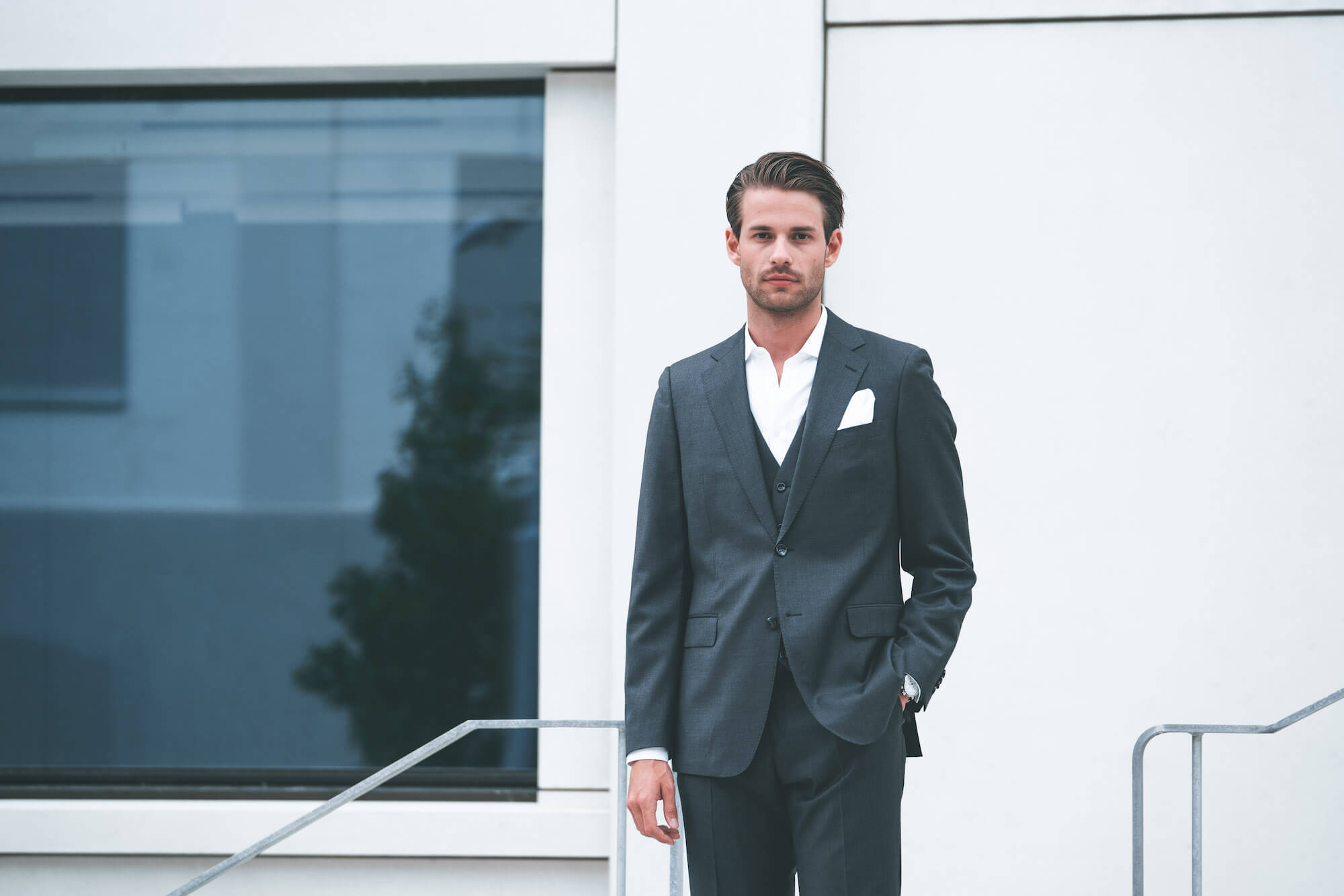 Junger Mann im grauen Anzug ohne Krawatte