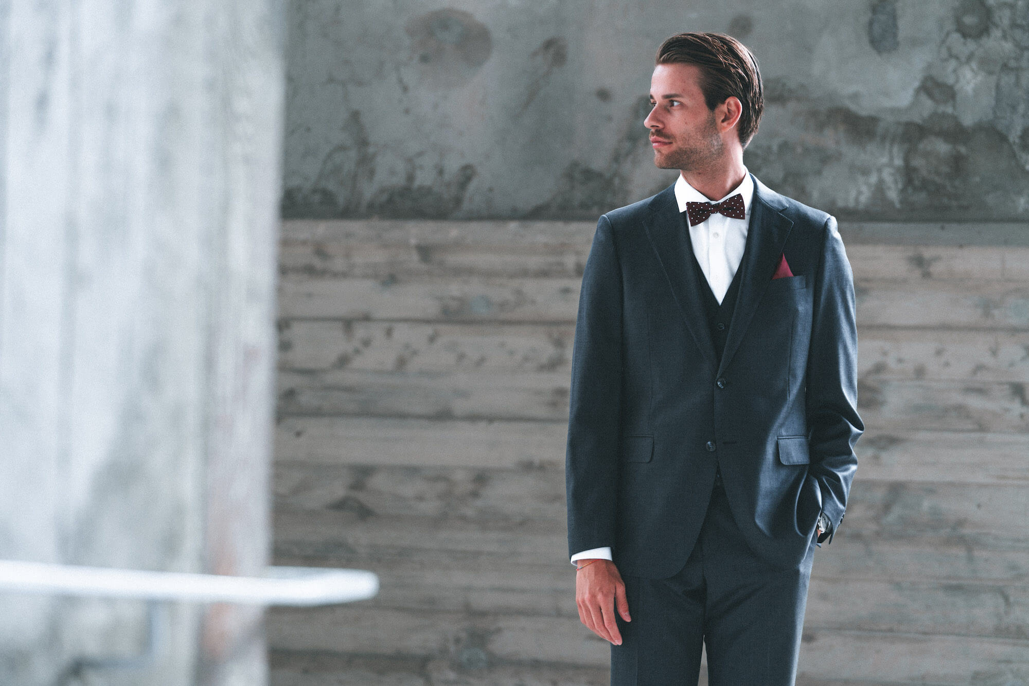 Junger Mann im Anzug und roter Schleife