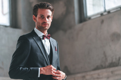 Mann im grauen Anzug mit roter Schleife und rotem Einstecktuch