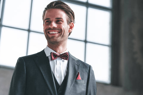 Mann im Anzug und roter gepunkteter Schleife